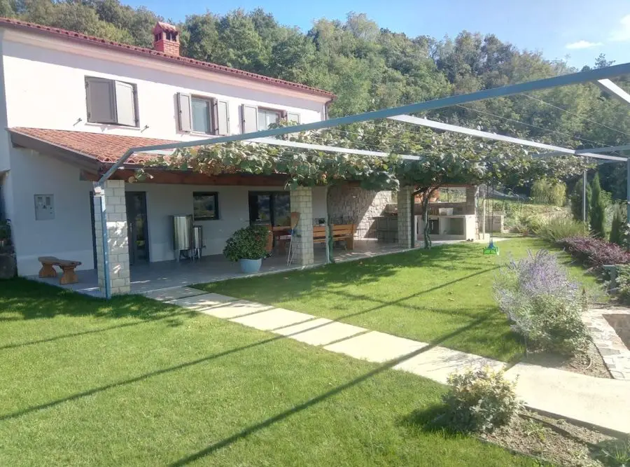 Landscaped garden with a pergola beside a family home